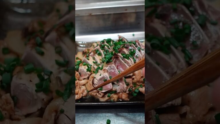 鰹のたたきを生姜焼きでいただく中年男性
